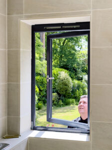 Fitter Installing aluminium Slimline windows man looking at window