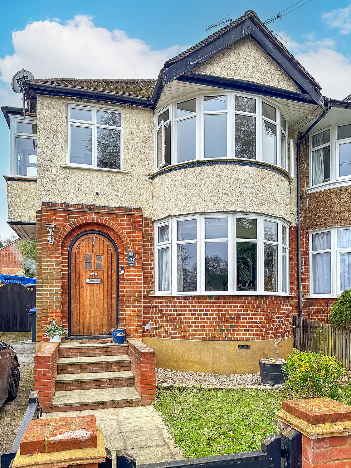 1930s semi-detached house with prominent two-storey white bay window, with new uPVC Slimline windows, energy-efficient replacement complete