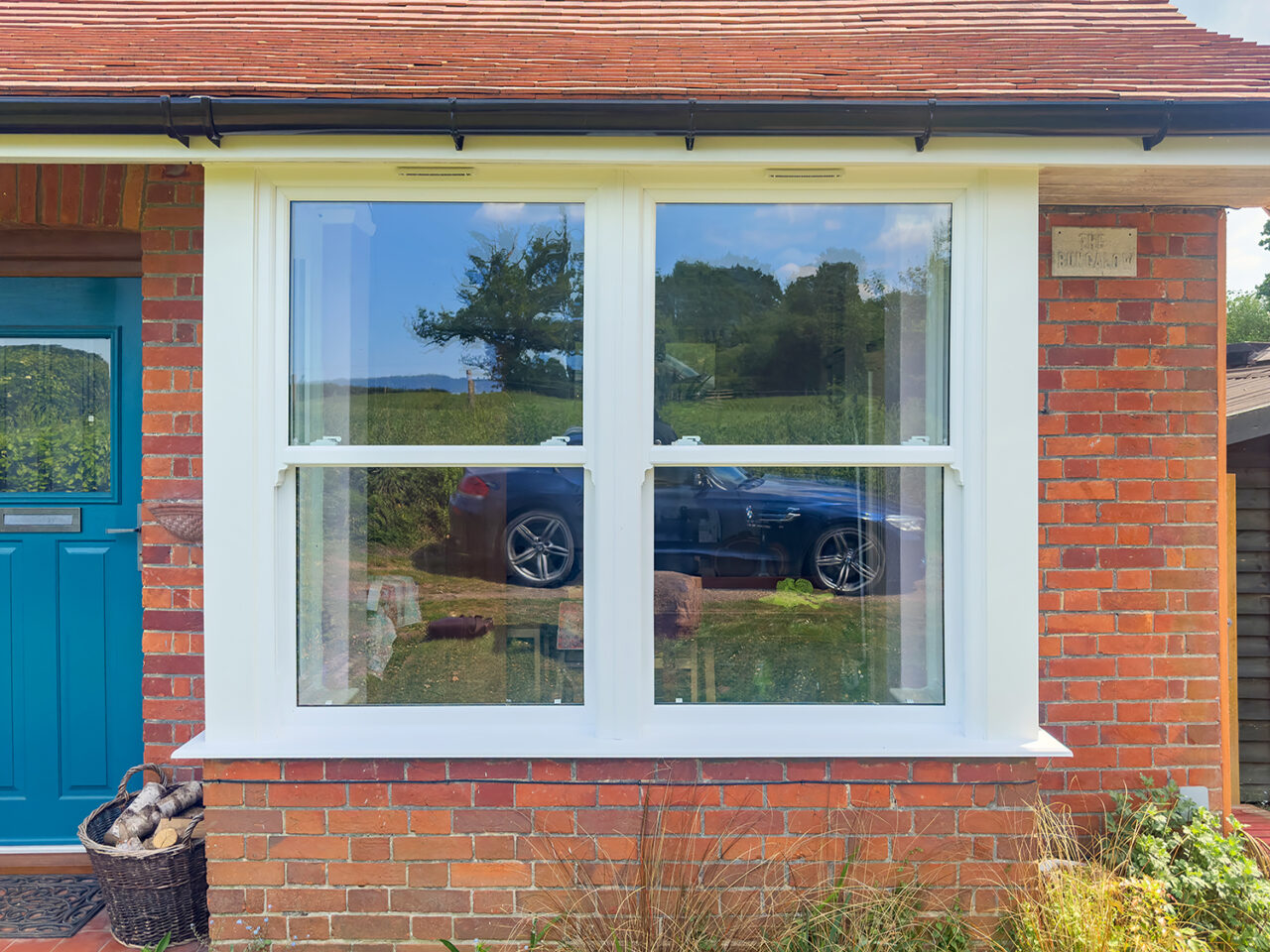 Beautiful period brick cottage featuring authentic-looking white uPVC sash windows with traditional proportions, demonstrating how modern uPVC windows perfectly complement heritage architecture while providing energy efficiency and low maintenance benefits