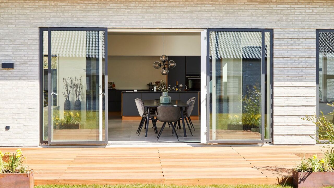 VEFLAC Sliding Doors in dark gray on patio leading to kitchen dining room on a new property. External view looking from outside into the property.
